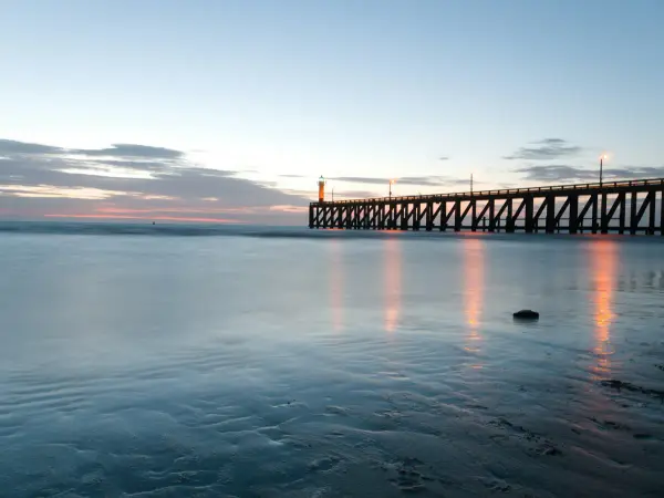 Blankenberge pier at dusk stretching into the calm North Sea, moody atmospheric view of the Belgian coast