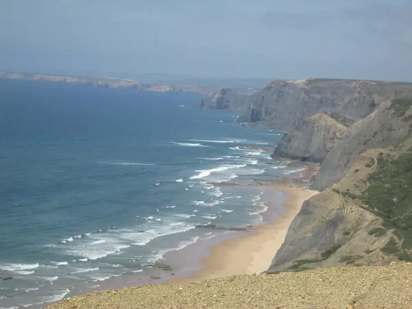 Praia da Boca do Rio beach with golden sand, dramatic cliffs and Roman ruins near Budens, Algarve