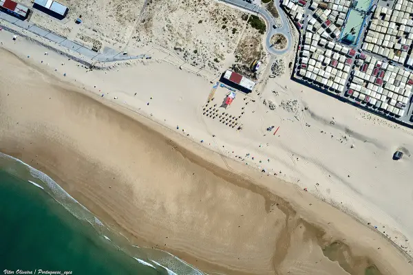 Praia da Cova do Vapor beach with fishing village and Tagus estuary near Lisbon