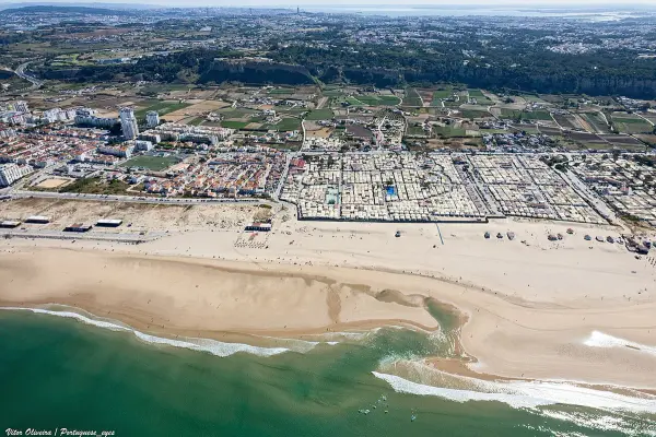 Praia da Cova do Vapor beach with fishing village and Tagus estuary near Lisbon